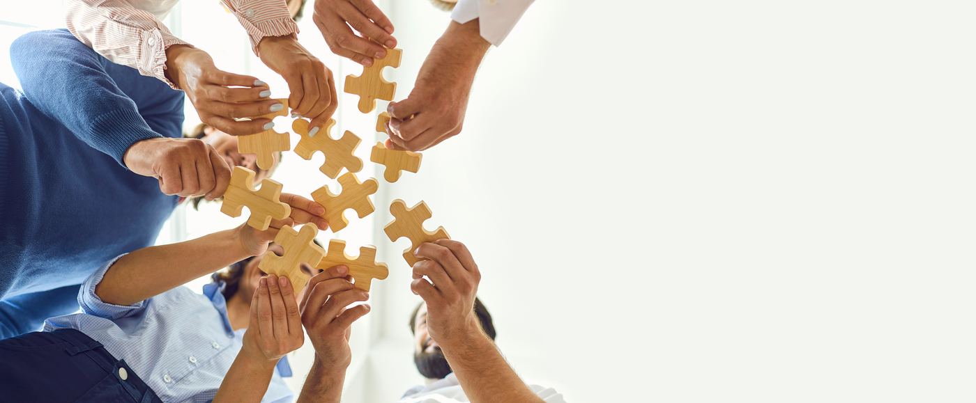 Hands joining puzzle pieces together